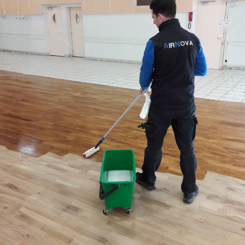 Nettoyage et entretien de sol en bois dans une salle collective